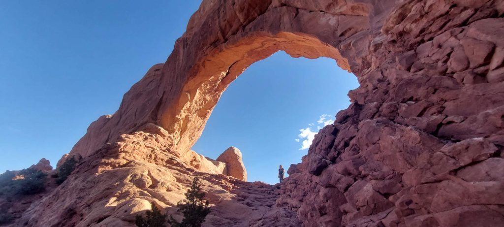 A person standing in Mesa Arch.