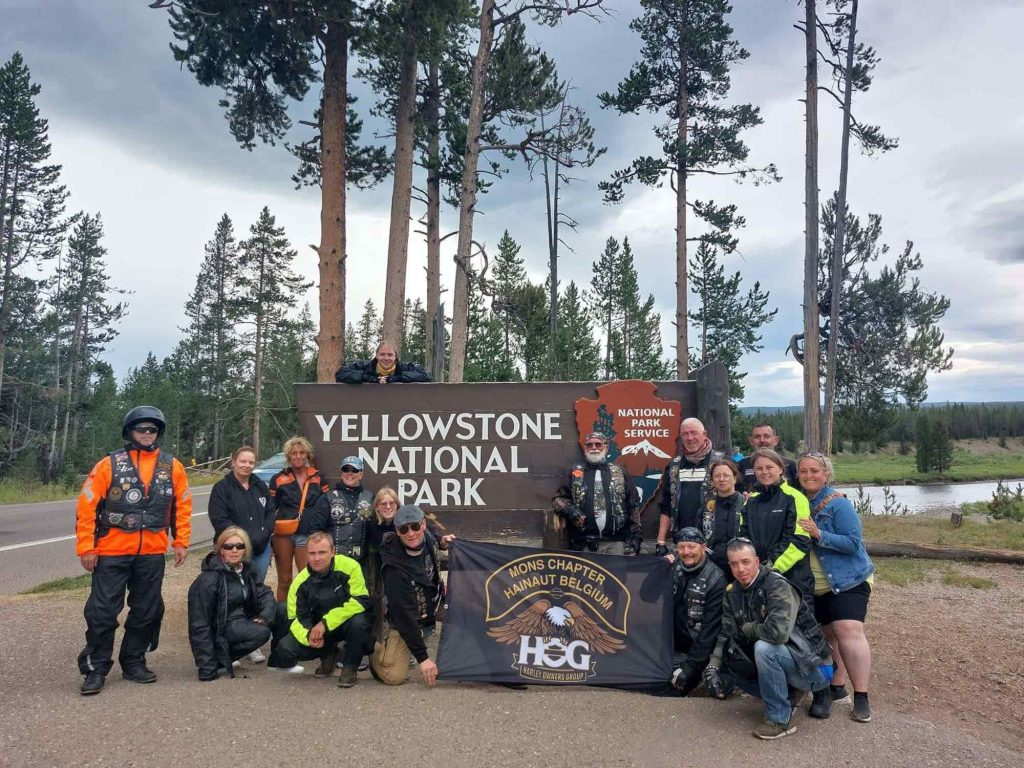 Belgium Mons Chapter members posing next to the Yellowstone National Park sign.