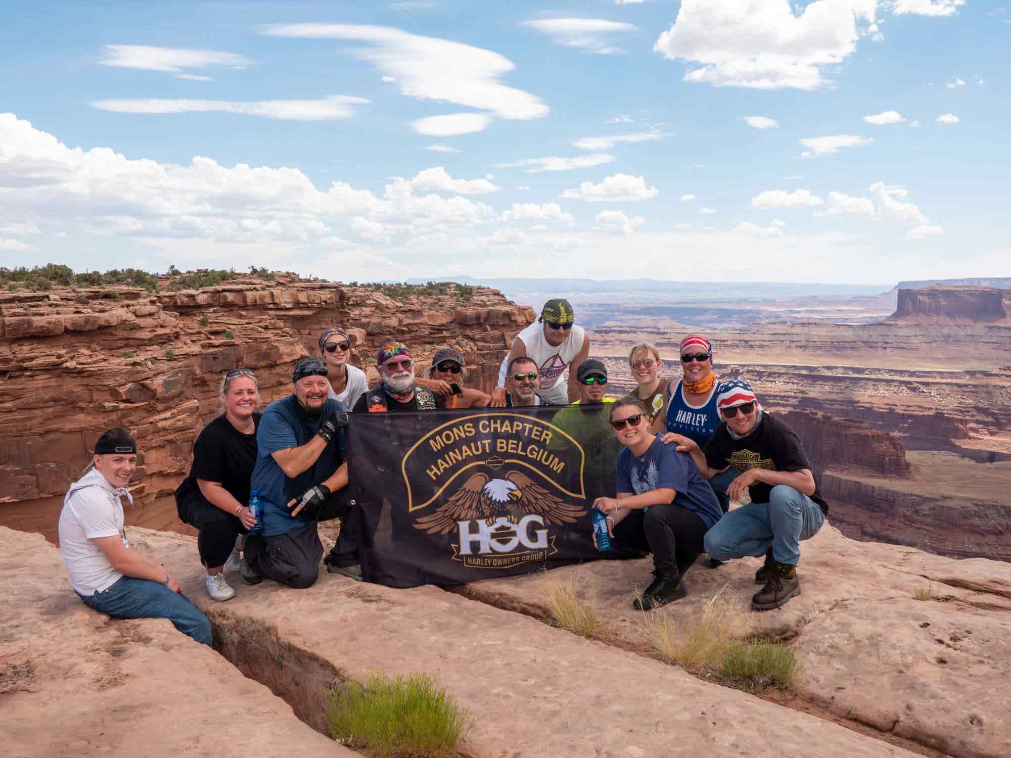 Belgium Mons Chapter members posing with a flag at Yellowstone National Park.