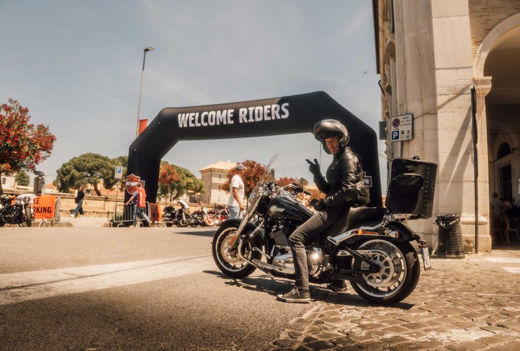 Motorcycle rider at the start of the event with sign saying 'Welcome Riders'