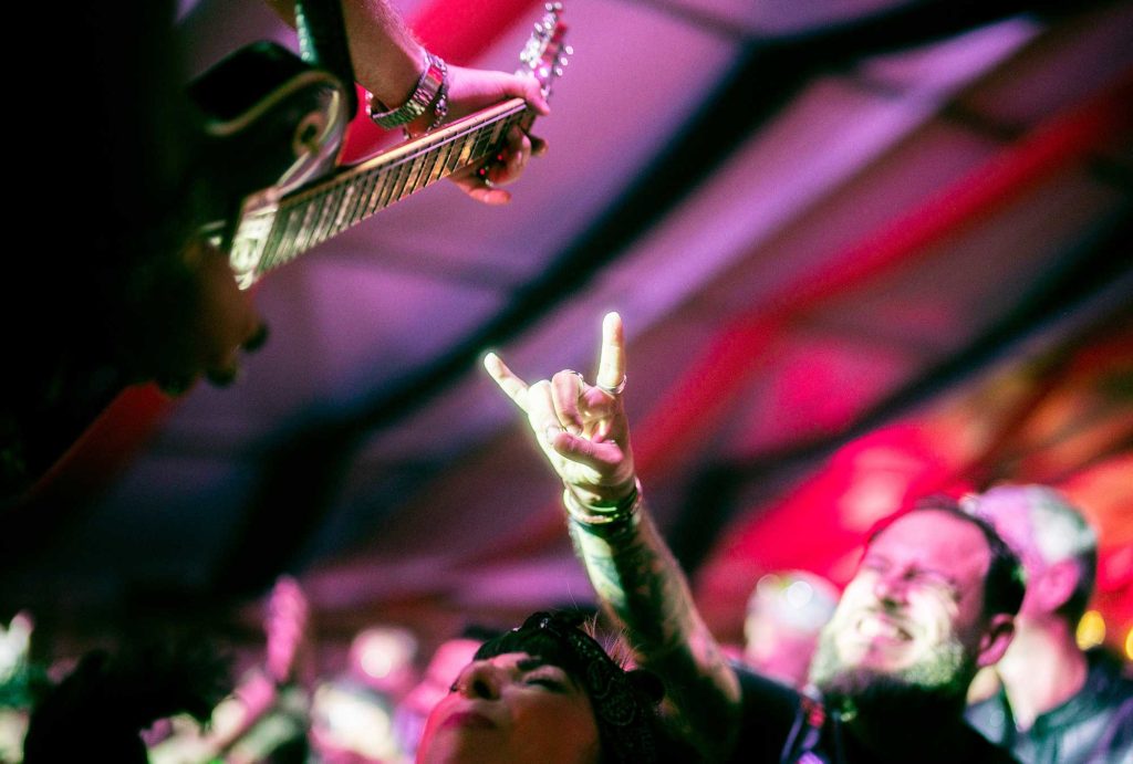 Band playing with guitar and crowd in the background