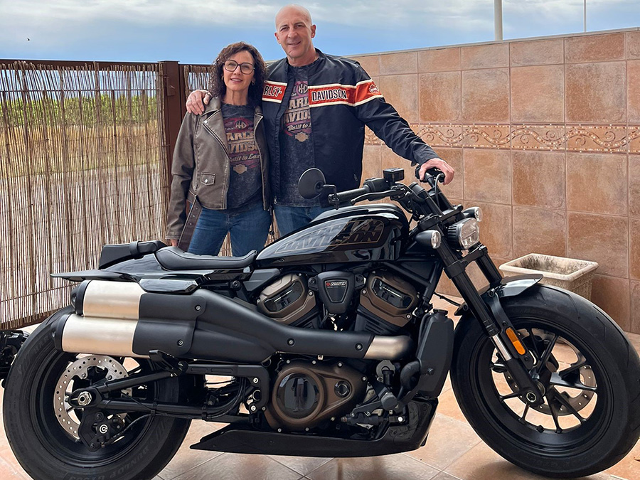 A couple standing beside a Harley-Davidson Sportser S