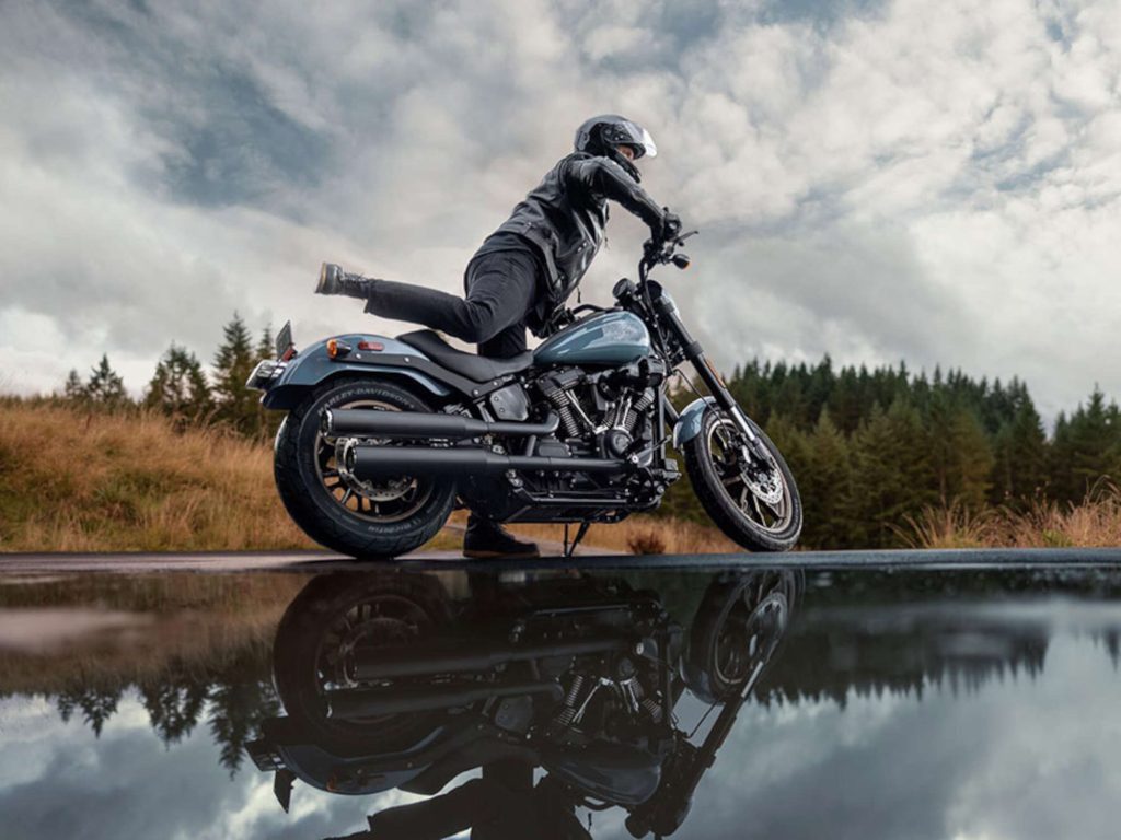 A person getting on a Harley-Davidson bike.