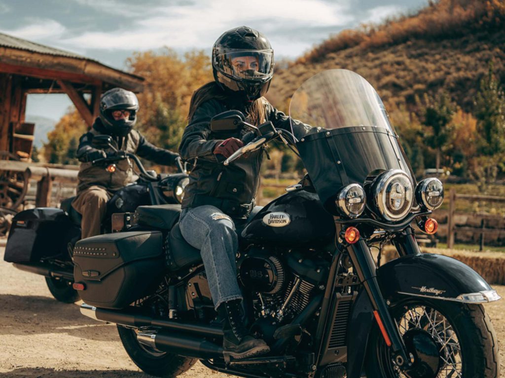 2 people sitting on Harley-Davidson bikes.