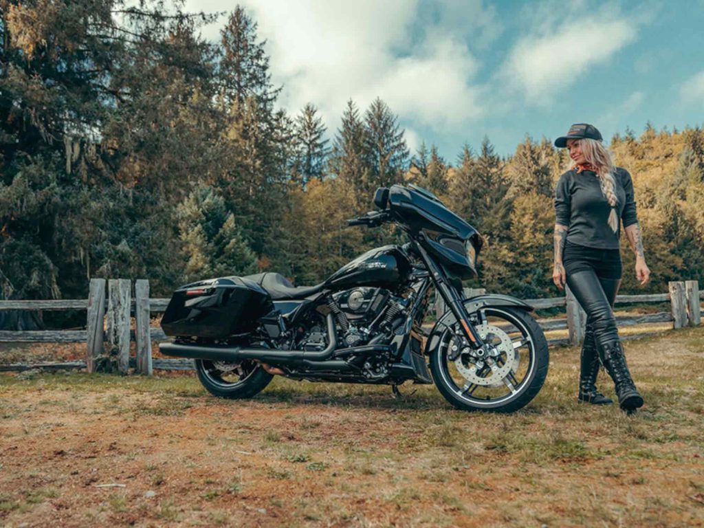 A person standing next to a Harley-Davidson.